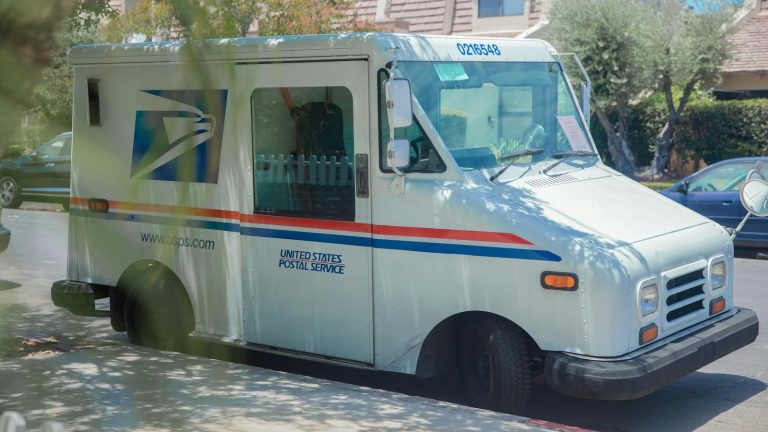 United States Postal Service van parked on a sunny street in Los Angeles, CA.
