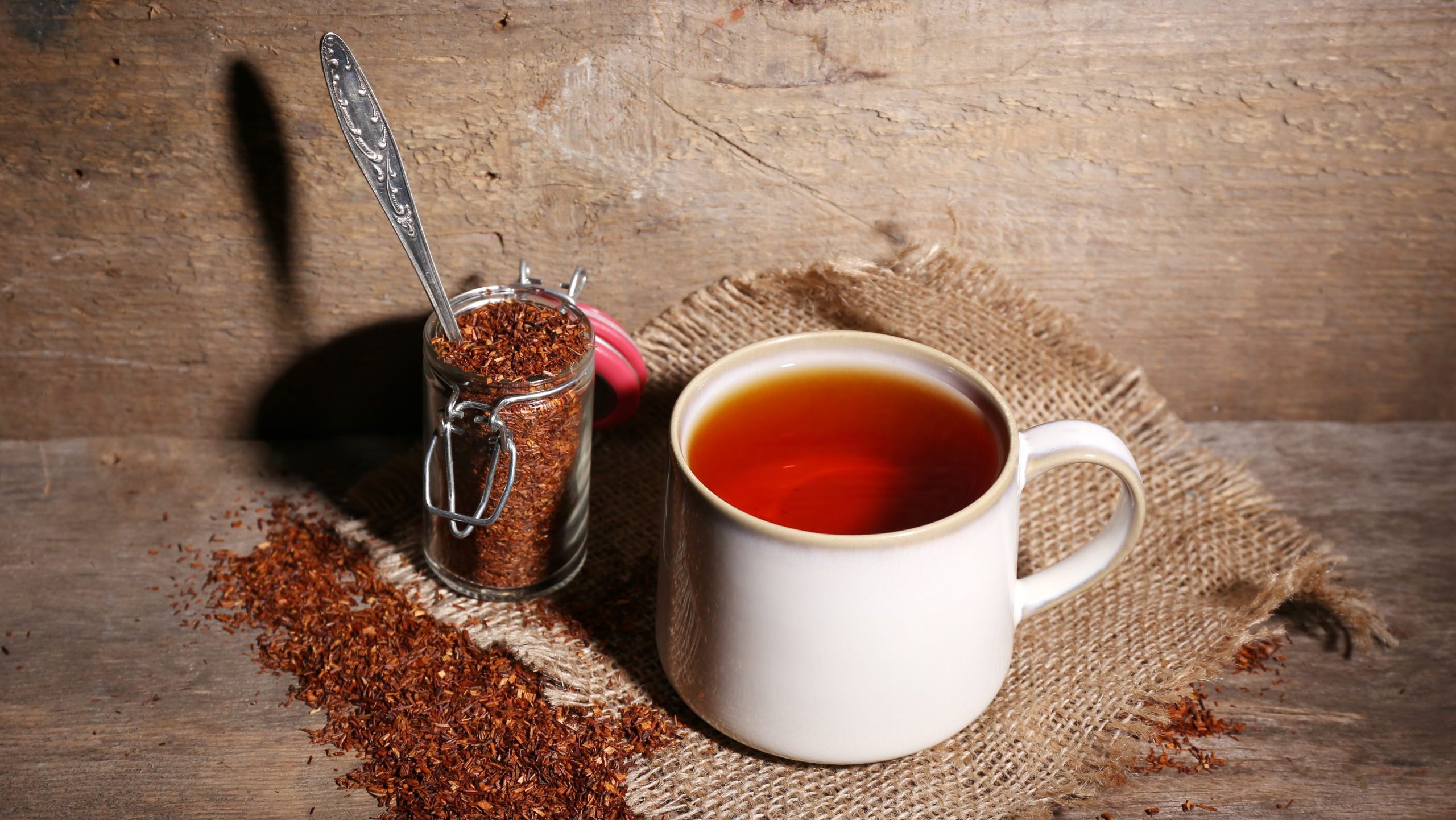 Cup of tasty rooibos tea, on wooden table