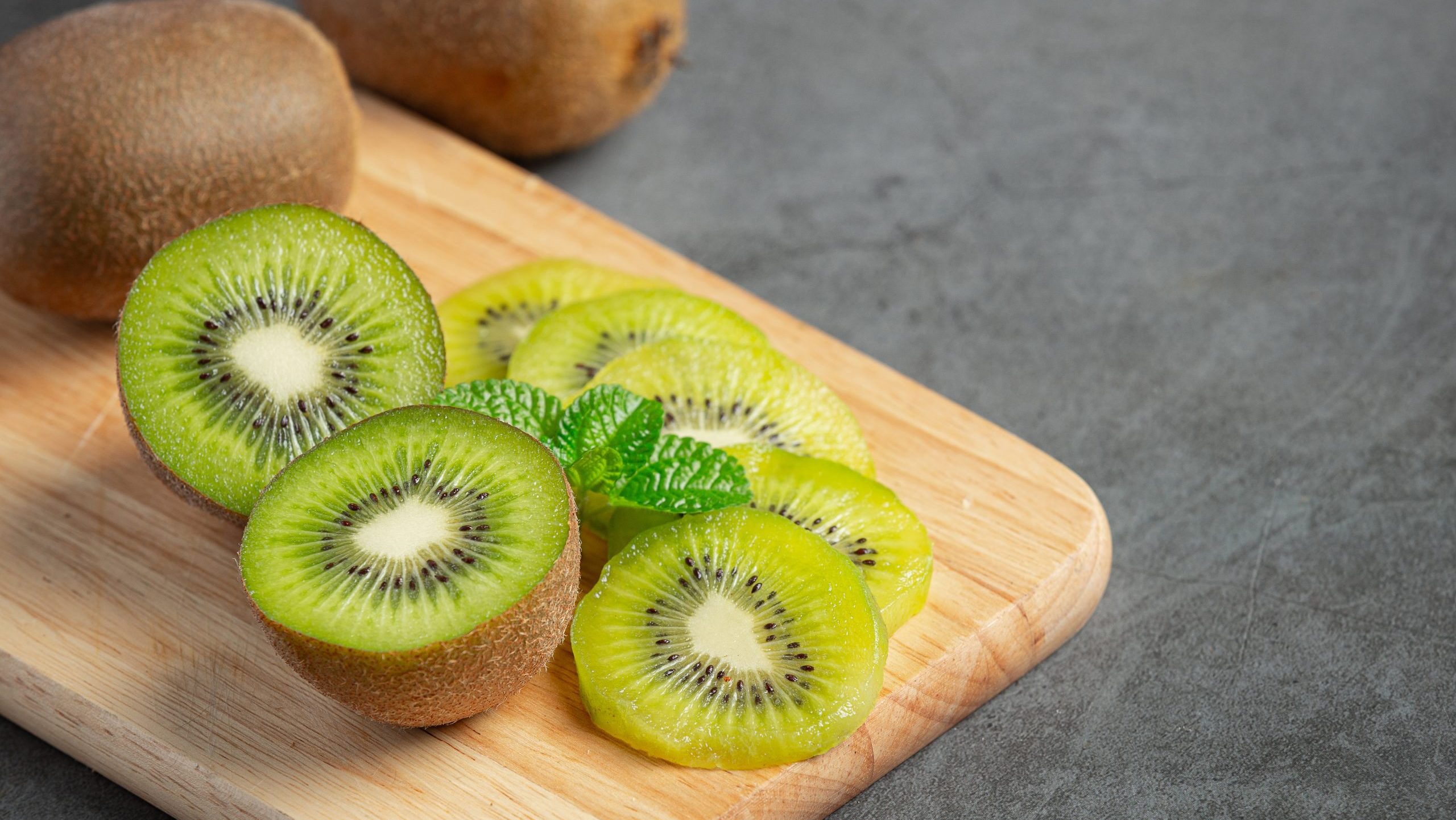 Fresh kiwi, cut into half, put on wooden cutting board