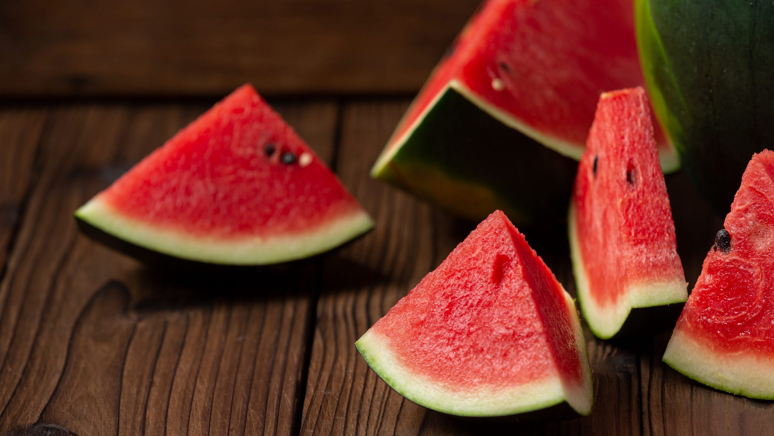 Red watermelon slice on wood background