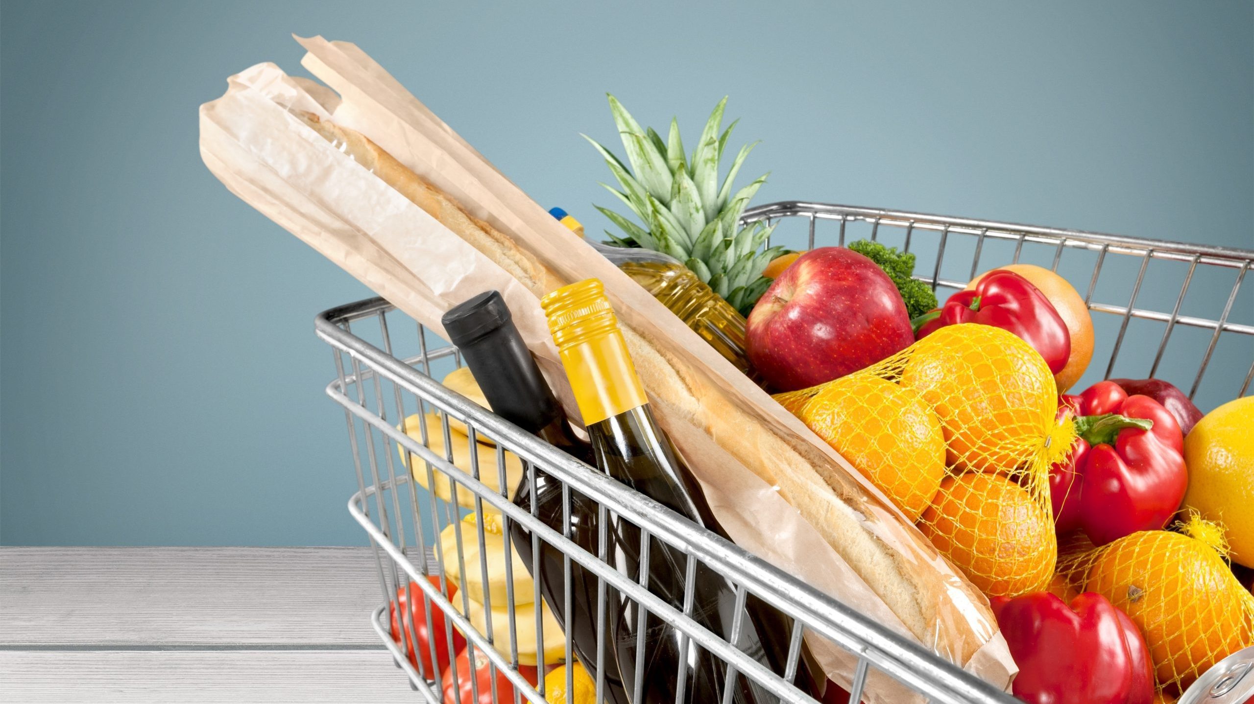 Shopping cart filled with various groceries in store