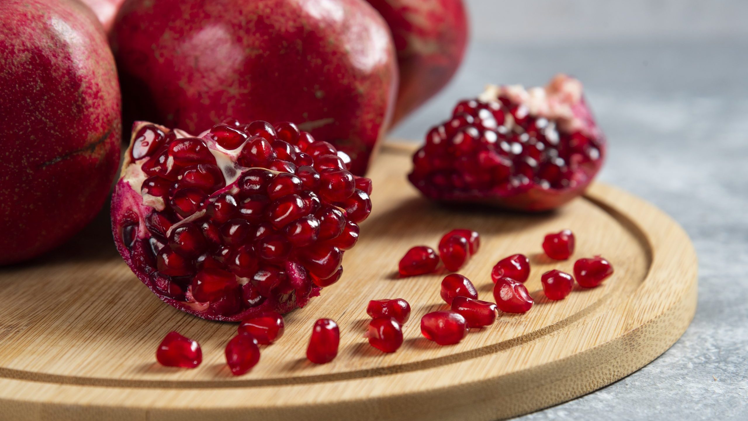Sliced ripe pomegranate on a wooden board. High quality photo