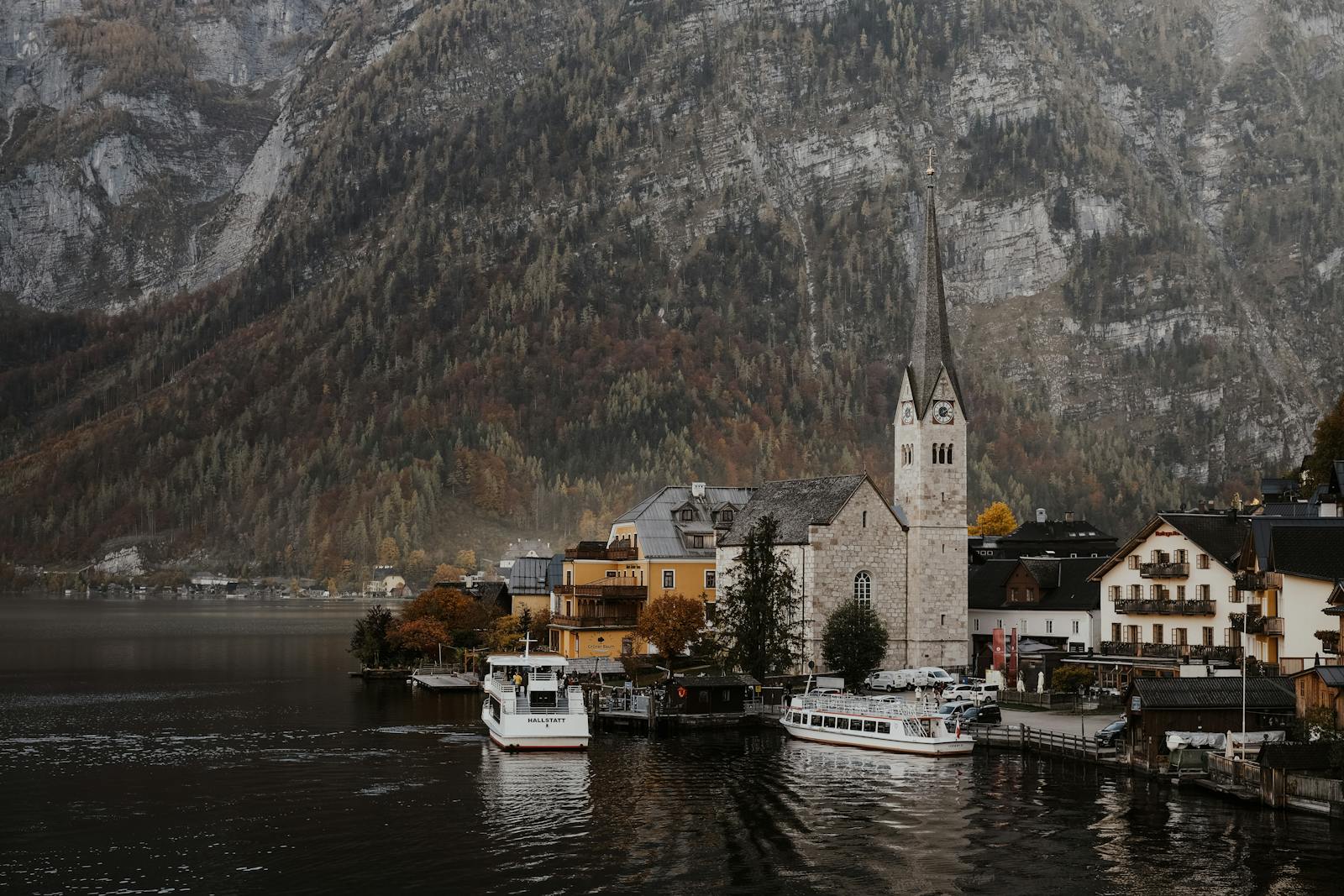 Picturesque view of Hallstatt with boats and mountains, showcasing Austria's scenic beauty.