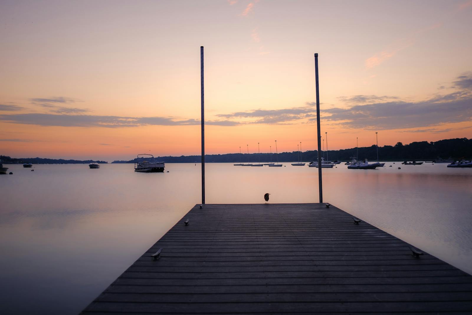 Serene view of a pier and calm waters at sunset in Orleans, Cape Cod, MA.