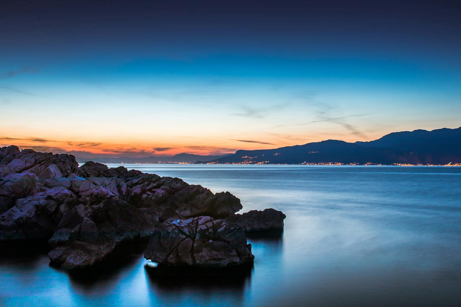 Beautiful sunset over rocky seashore in Split-Dalmatia County, Croatia with vibrant colors.