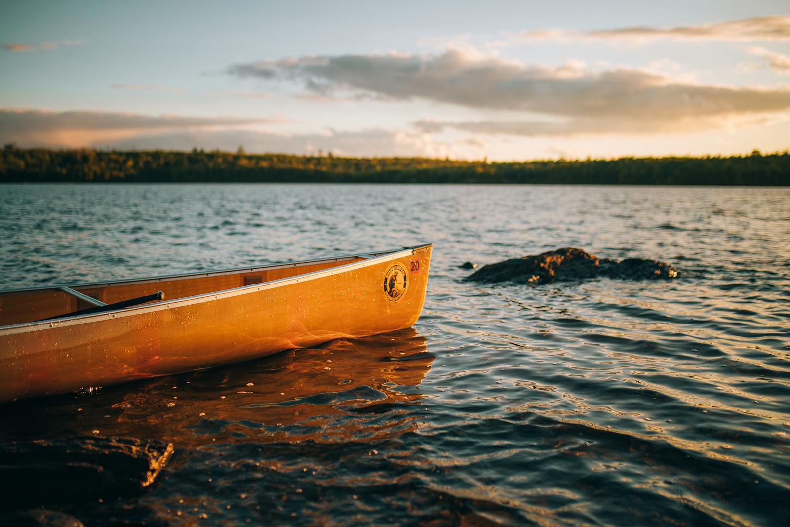 Serene view of a canoe by the lakeside at sunrise, creating a peaceful and adventurous mood in Ely, MN.