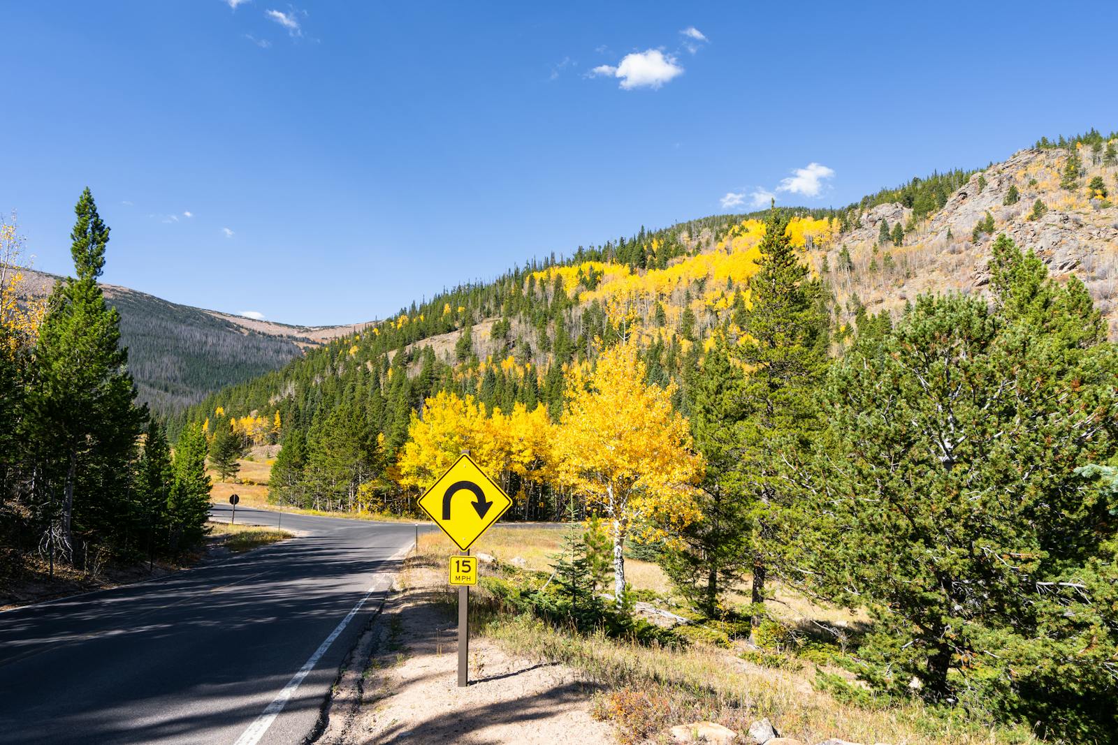 Enjoy the vibrant fall colors along a scenic mountain road in Colorado.
