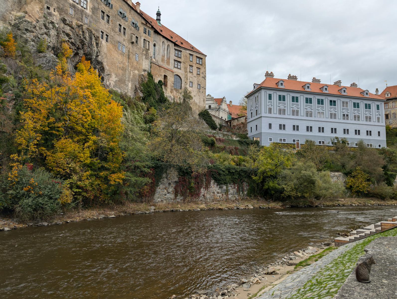 Scenic view of Český Krumlov Castle with autumn foliage and river.