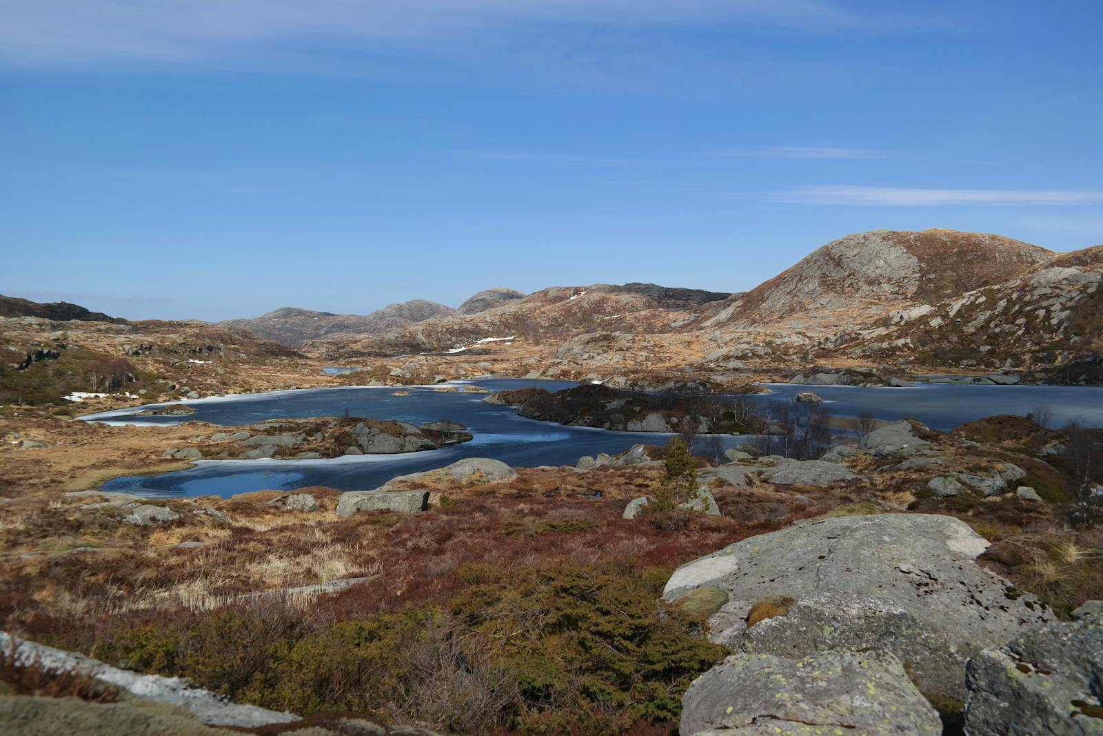 Beautiful mountain landscape with lakes and rocks in Etne, Vestland, Norway, under a clear blue sky.