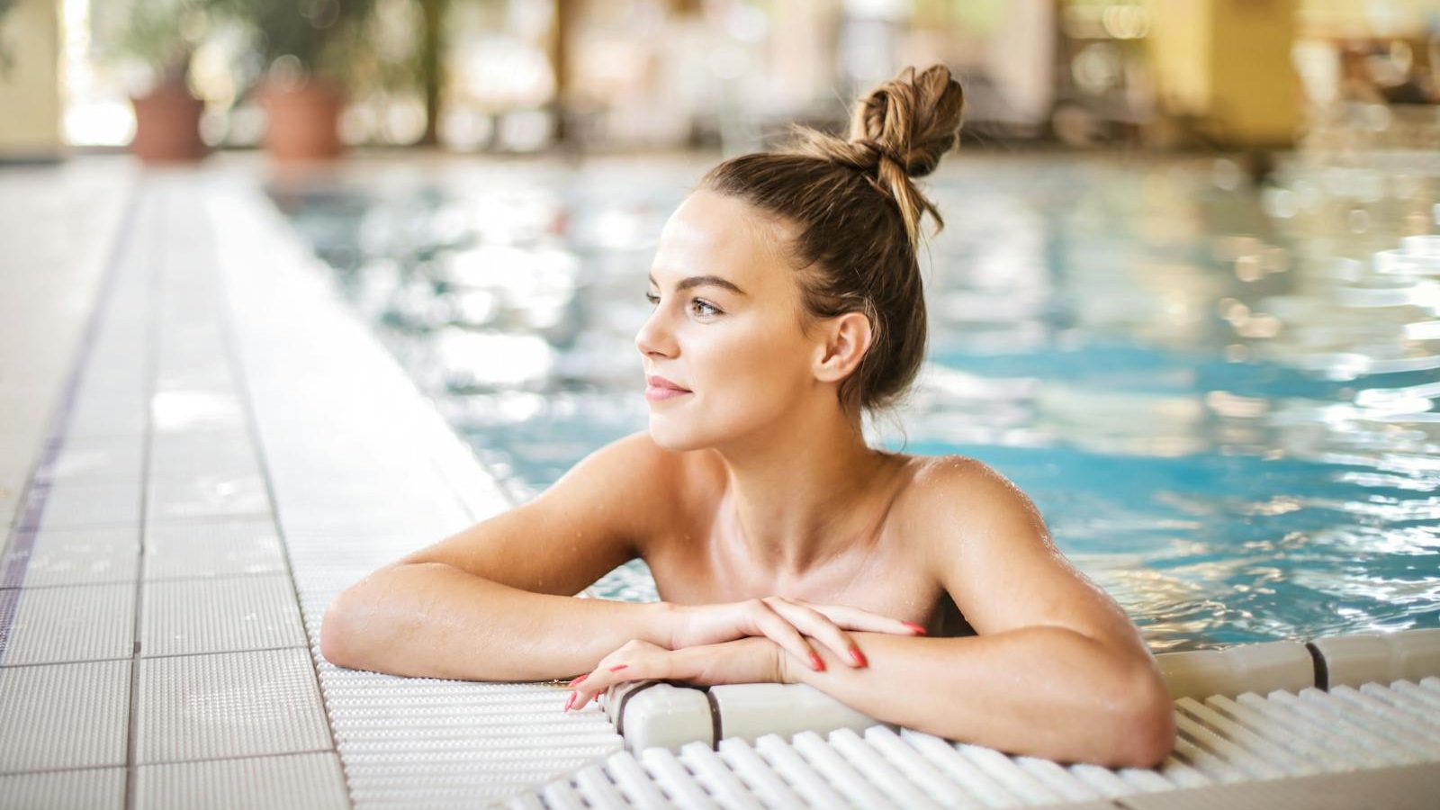 A serene moment as a woman relaxes in a poolside setting at a luxurious resort, enjoying the summer vibes.