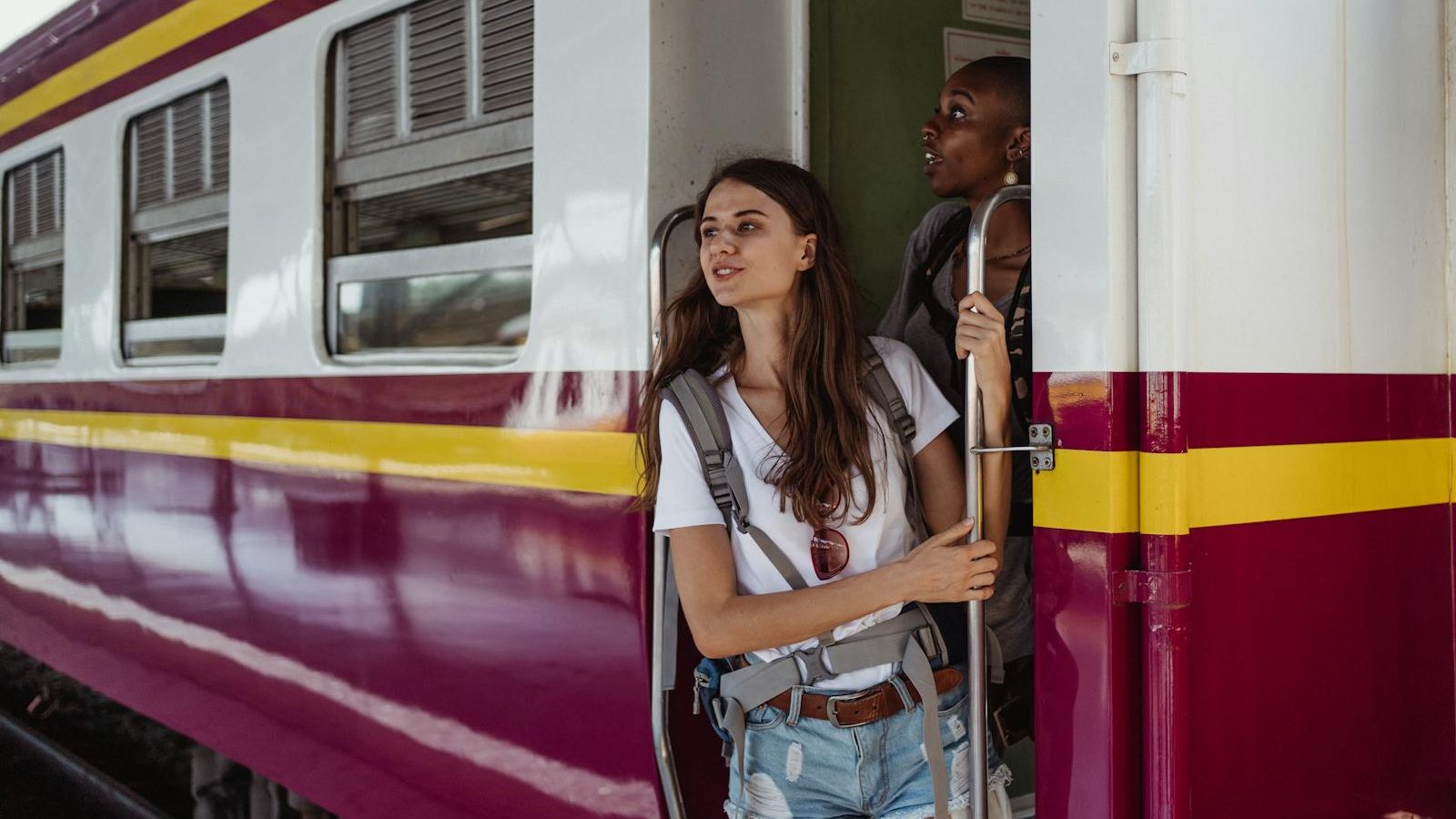 Two women enjoy a scenic train ride, capturing the essence of travel and exploration.