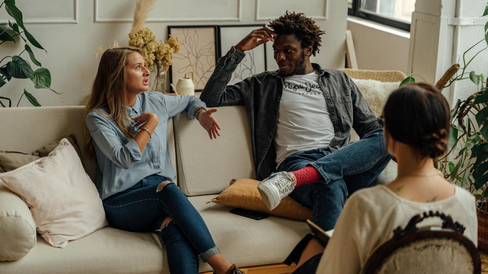 A couple is engaged in a lively conversation during a therapy session with a counselor.