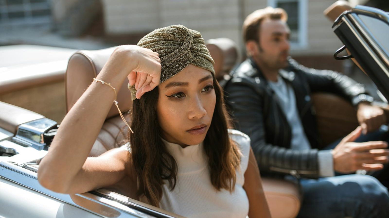 A couple having an intense discussion while seated in a convertible car.