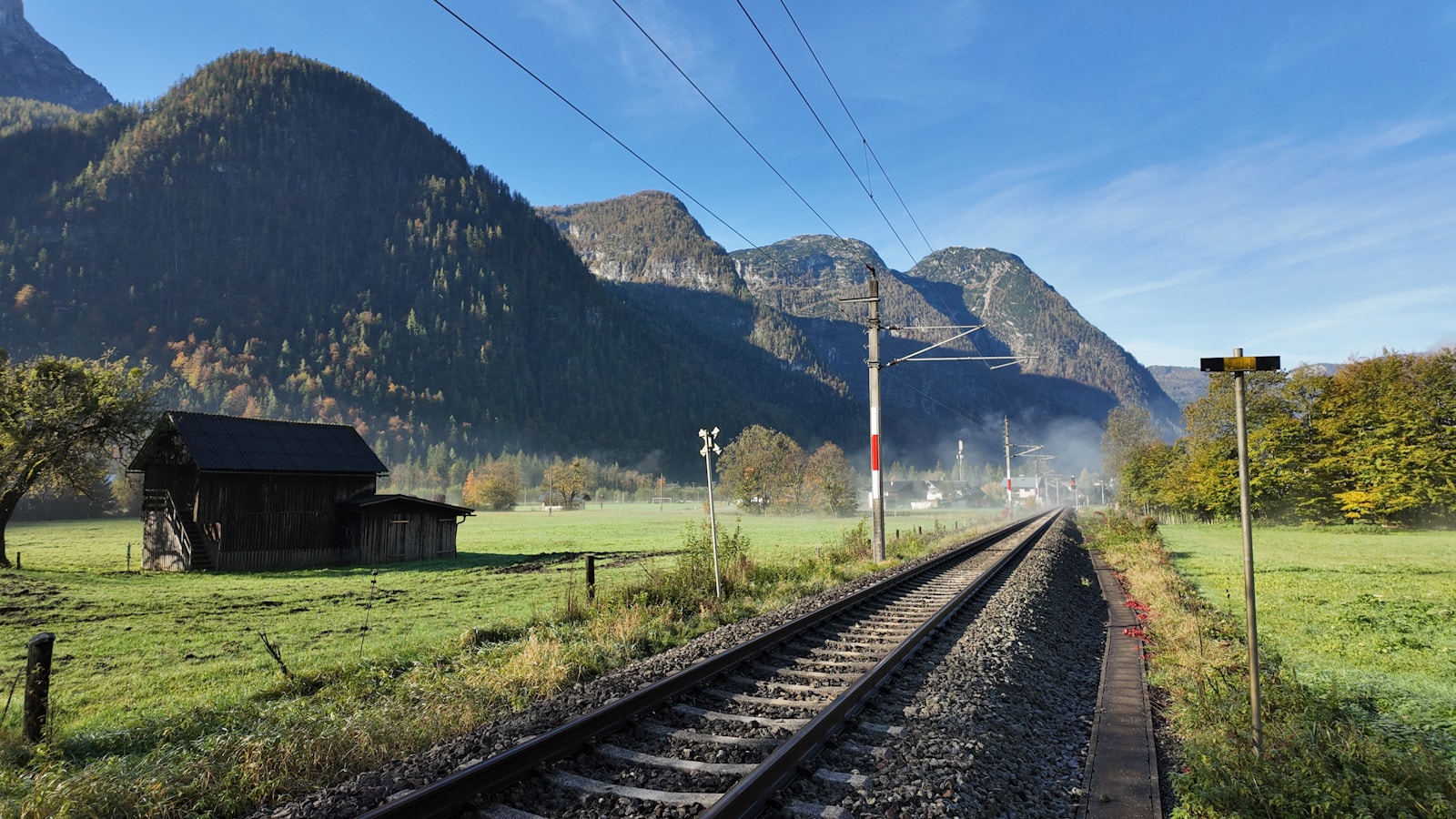 Railway tracks leading toward mountain peaks.