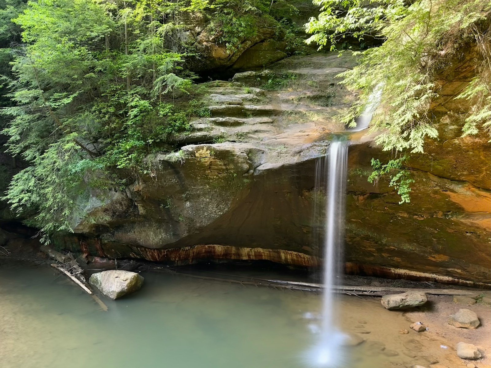 a small waterfall in the middle of a forest