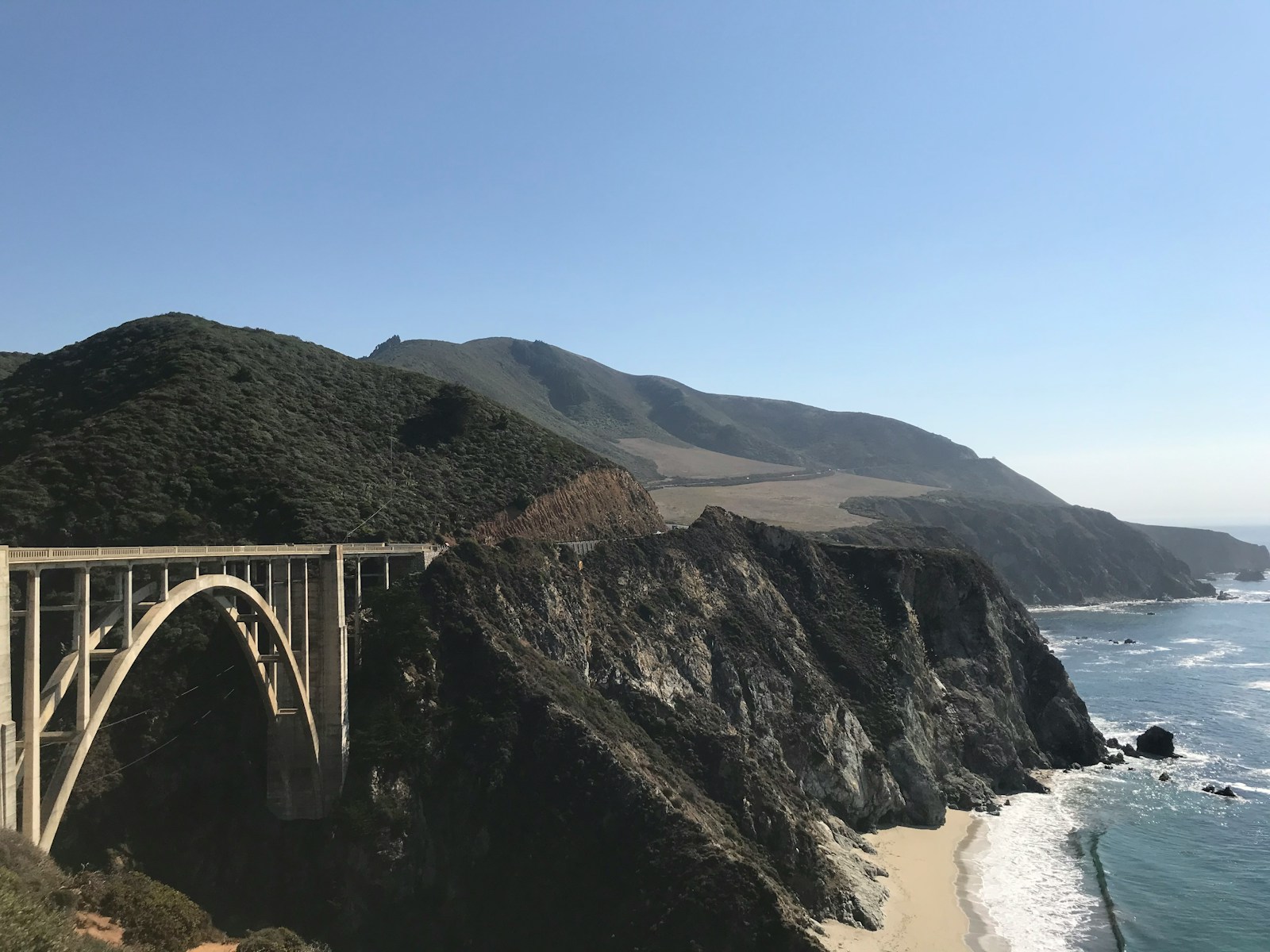 white bridge over the sea during daytime
