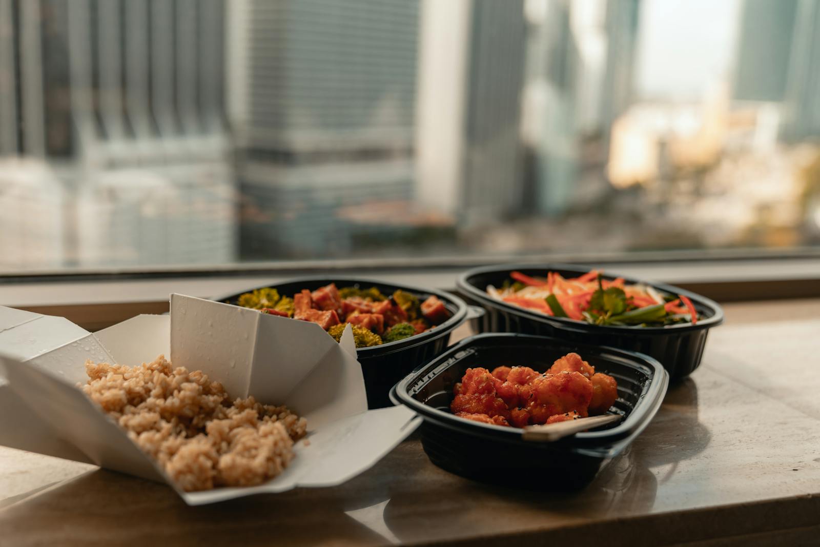 Enjoy a delicious Asian takeout meal with a stunning view of Miami's skyline from a high-rise window.