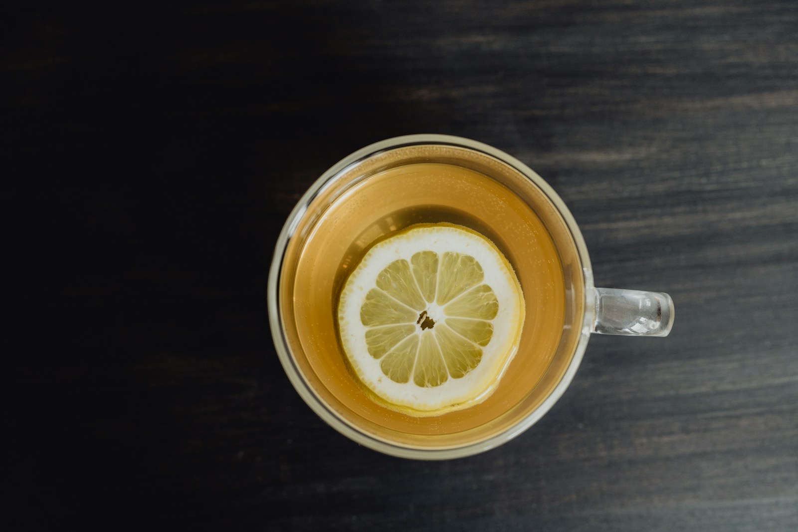 a cup of tea with a lemon slice in it