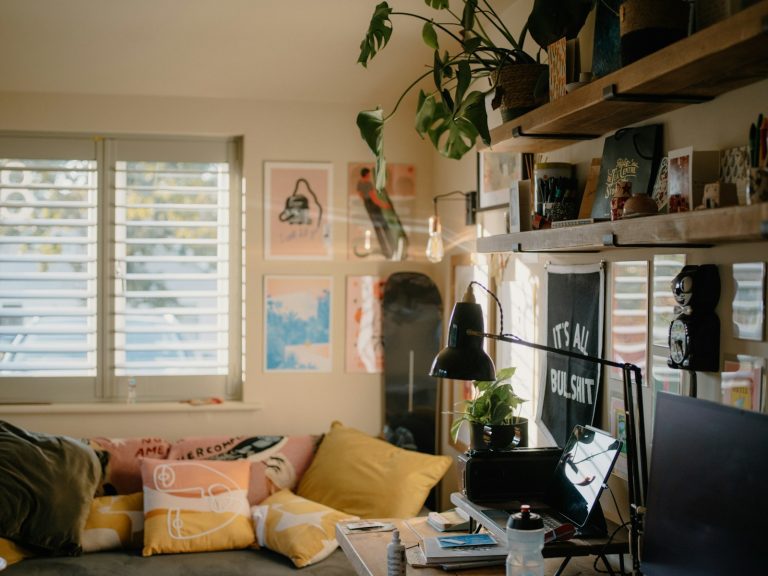Cozy room with plants, artwork, and a desk.