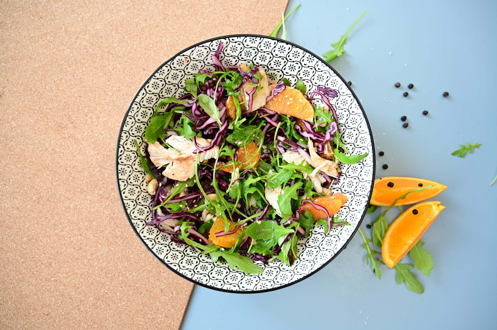 a salad with oranges and greens in a bowl