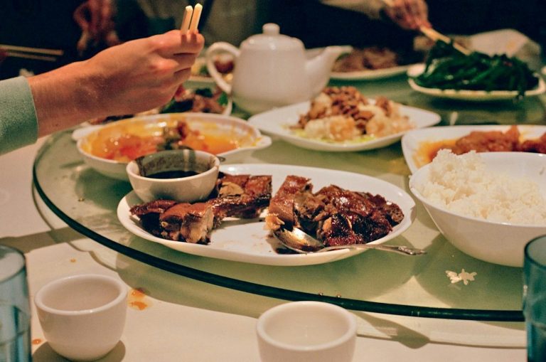A group of people sitting around a table with plates of food