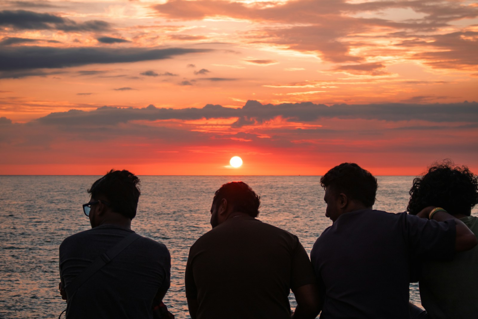 Friends watch the sunset together.