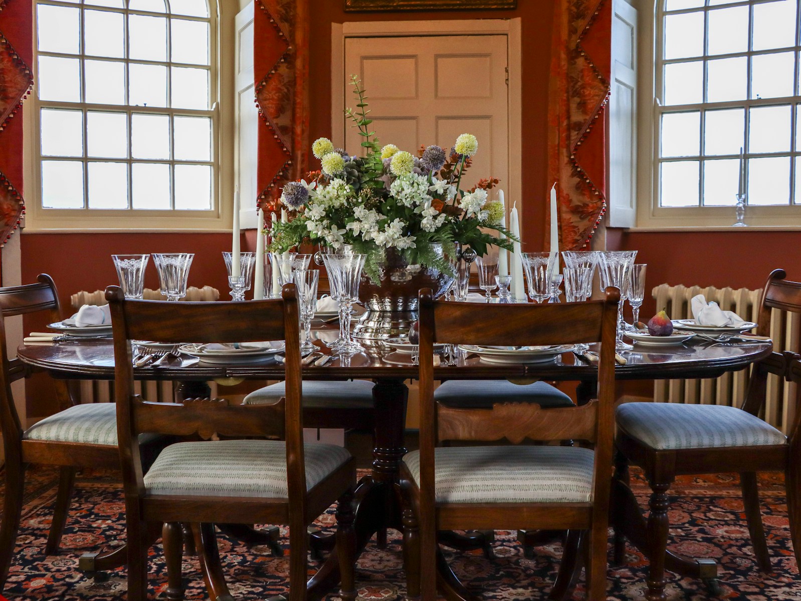 Elegant dining table set with floral centerpiece and candles.