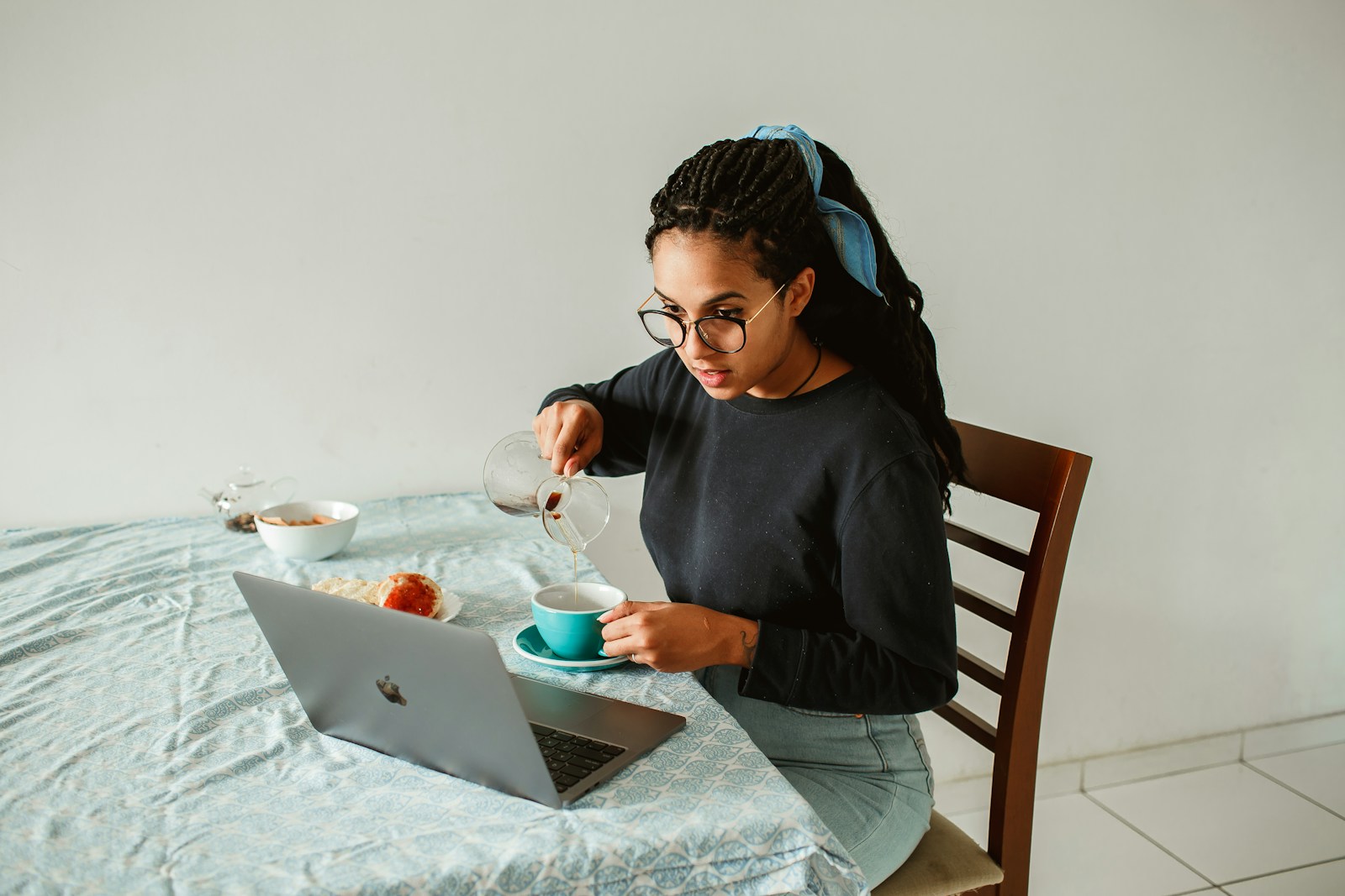 woman in black long sleeve shirt sitting on brown wooden chair