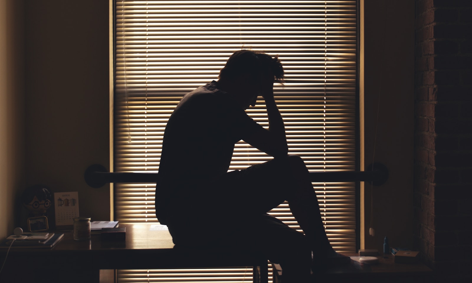 A silhouetted person appears worried and alone.