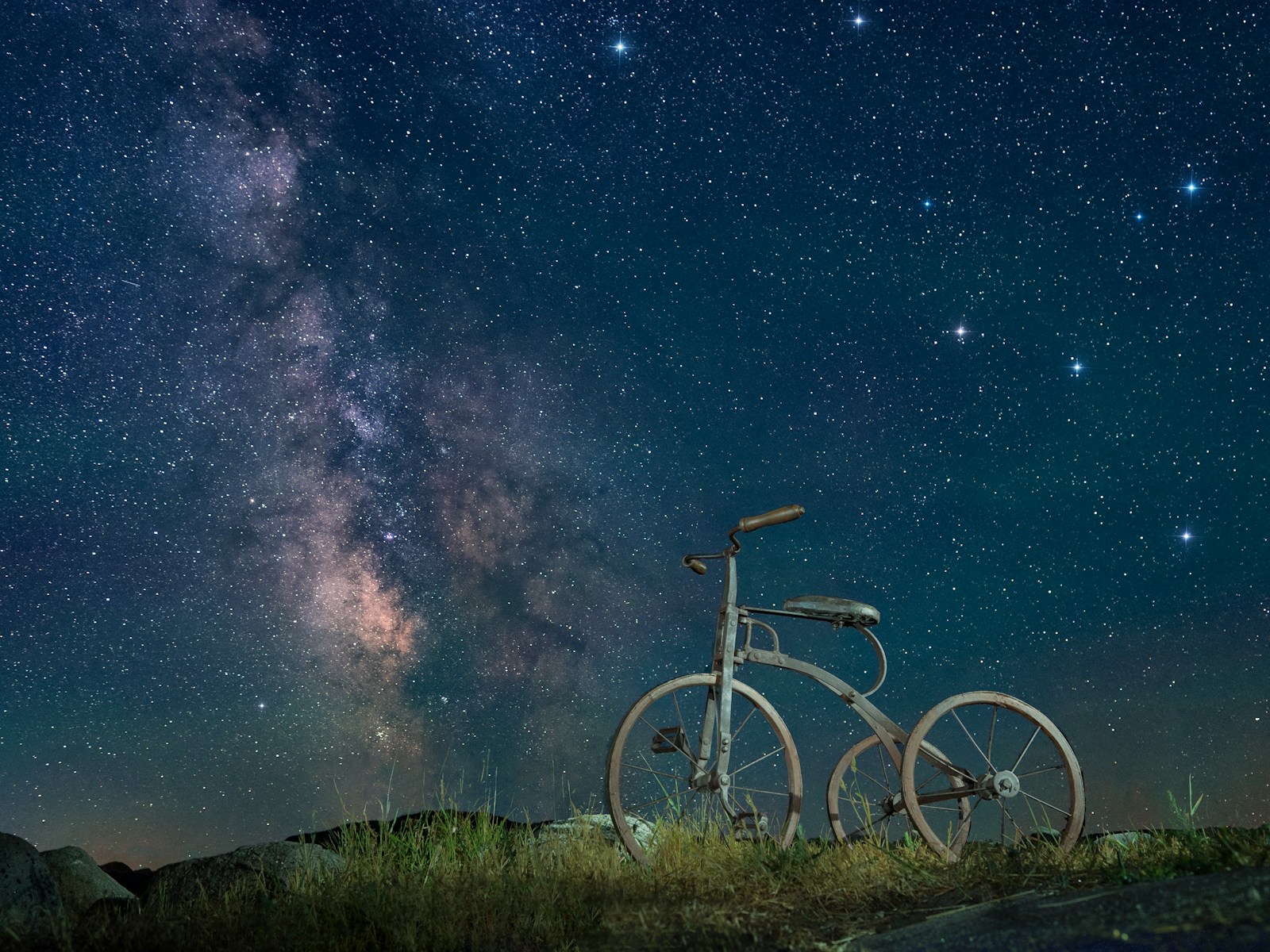 black commuter bike on green grass field under starry night
