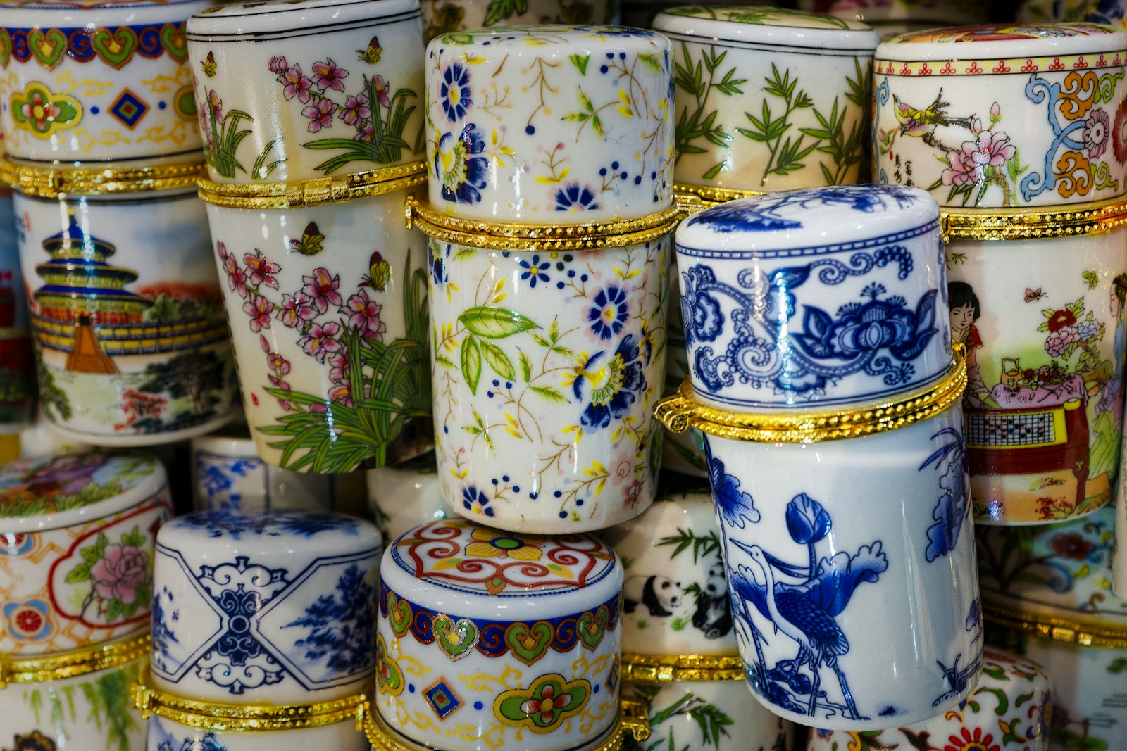 A bunch of different colored vases stacked on top of each other