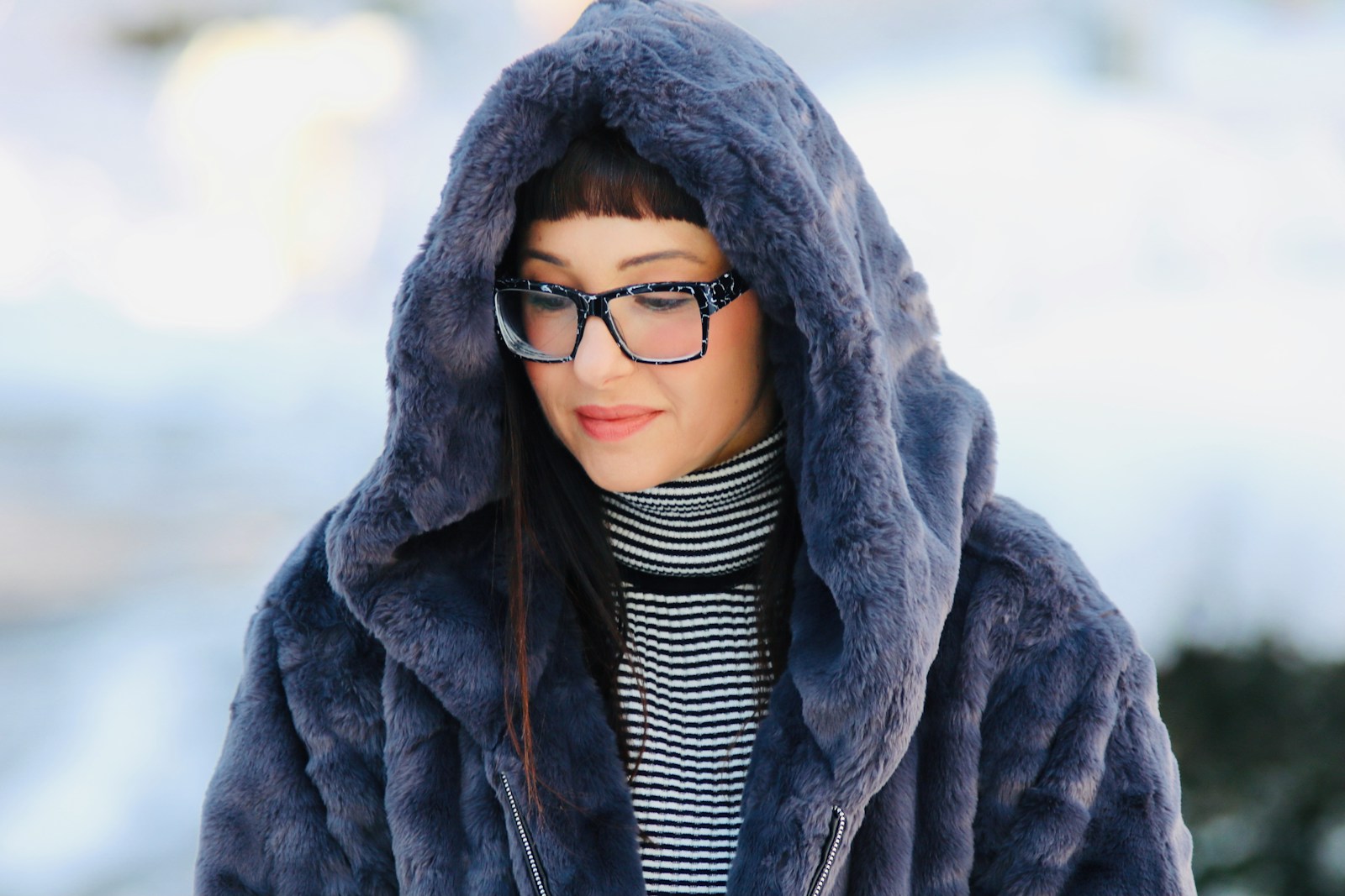 a woman wearing glasses and a fur coat