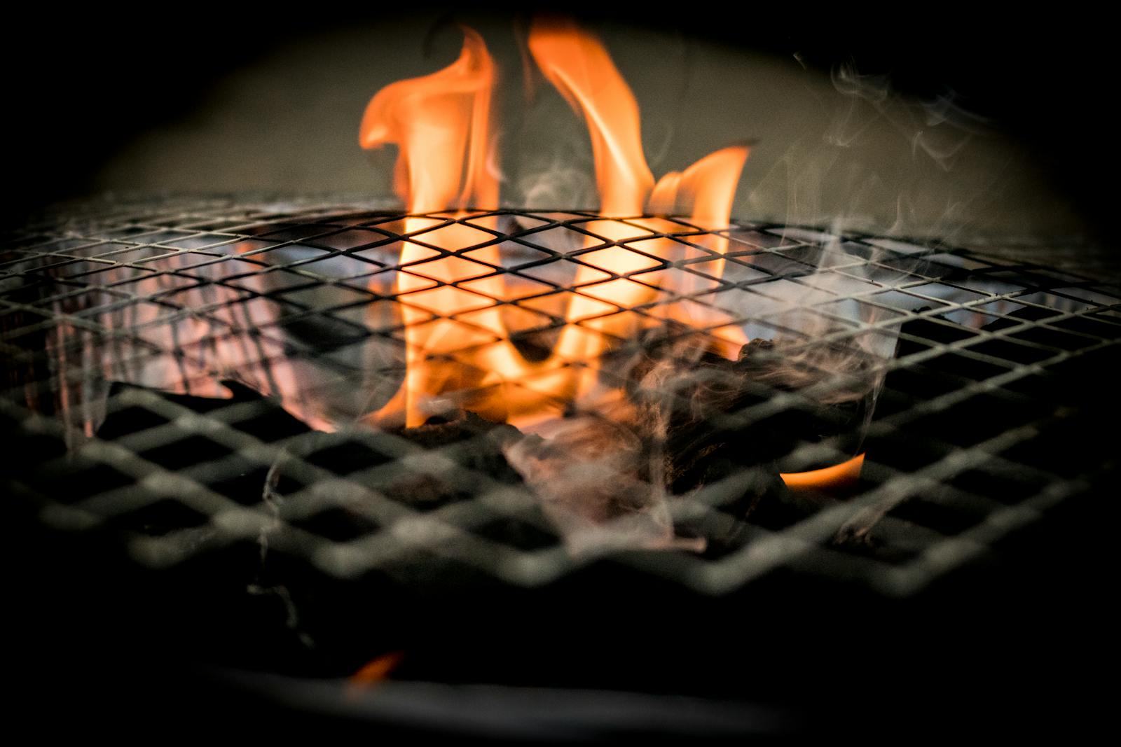 Vivid flames dance over a grill, ideal for cooking concepts and barbecue themes.