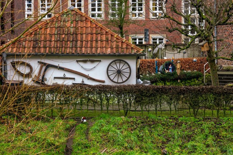A quaint rural setting highlighting traditional farm tools on a brick house wall, reflecting rustic charm.