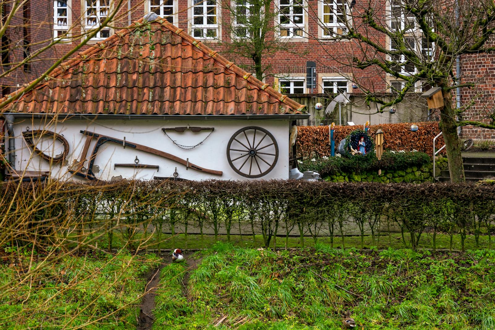 A quaint rural setting highlighting traditional farm tools on a brick house wall, reflecting rustic charm.