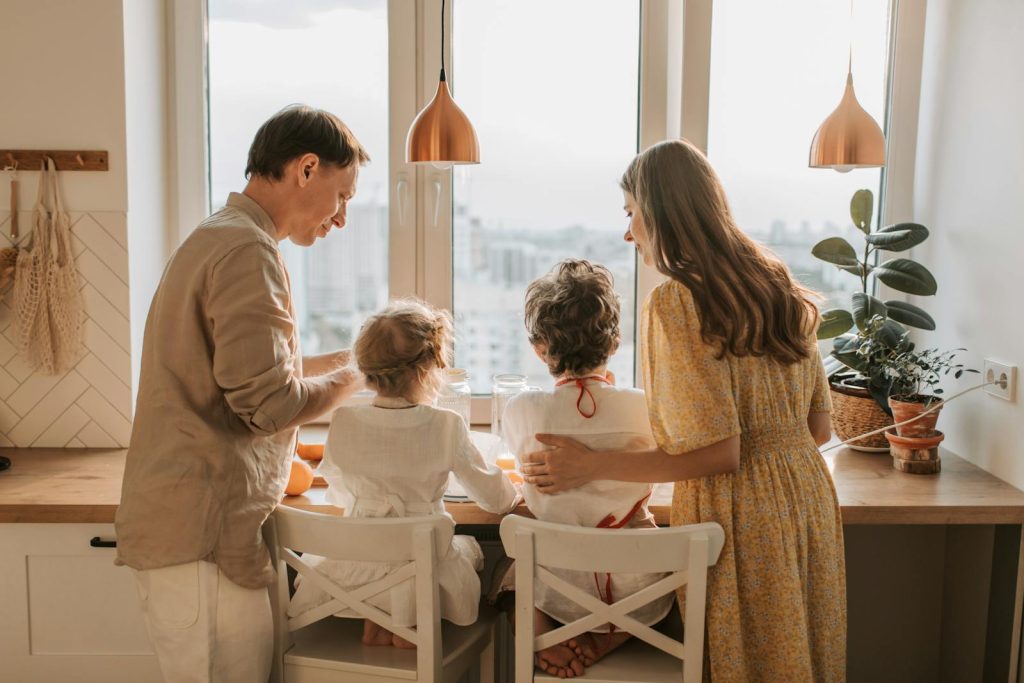 A family enjoying breakfast together in a warm sunlit kitchen, fostering togetherness.