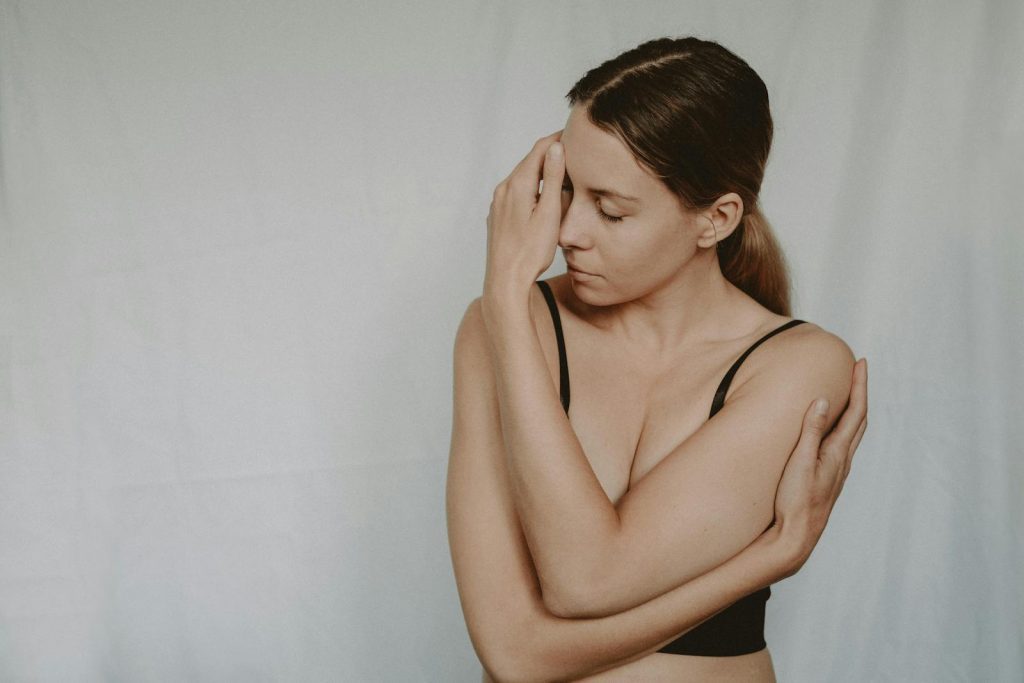A woman with closed eyes expressing emotion and introspection indoors.
