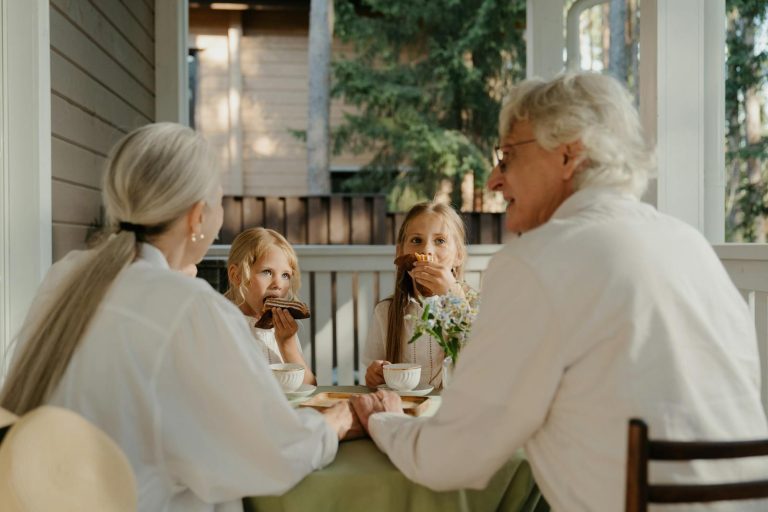Grandparents enjoying quality time with their grandchildren at a patio table.
