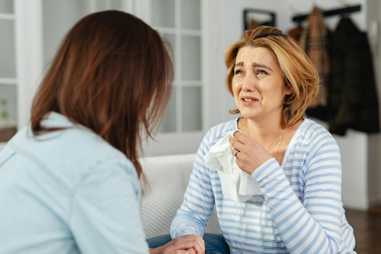 A woman receiving comfort from a friend, illustrating empathy and support in a difficult moment.