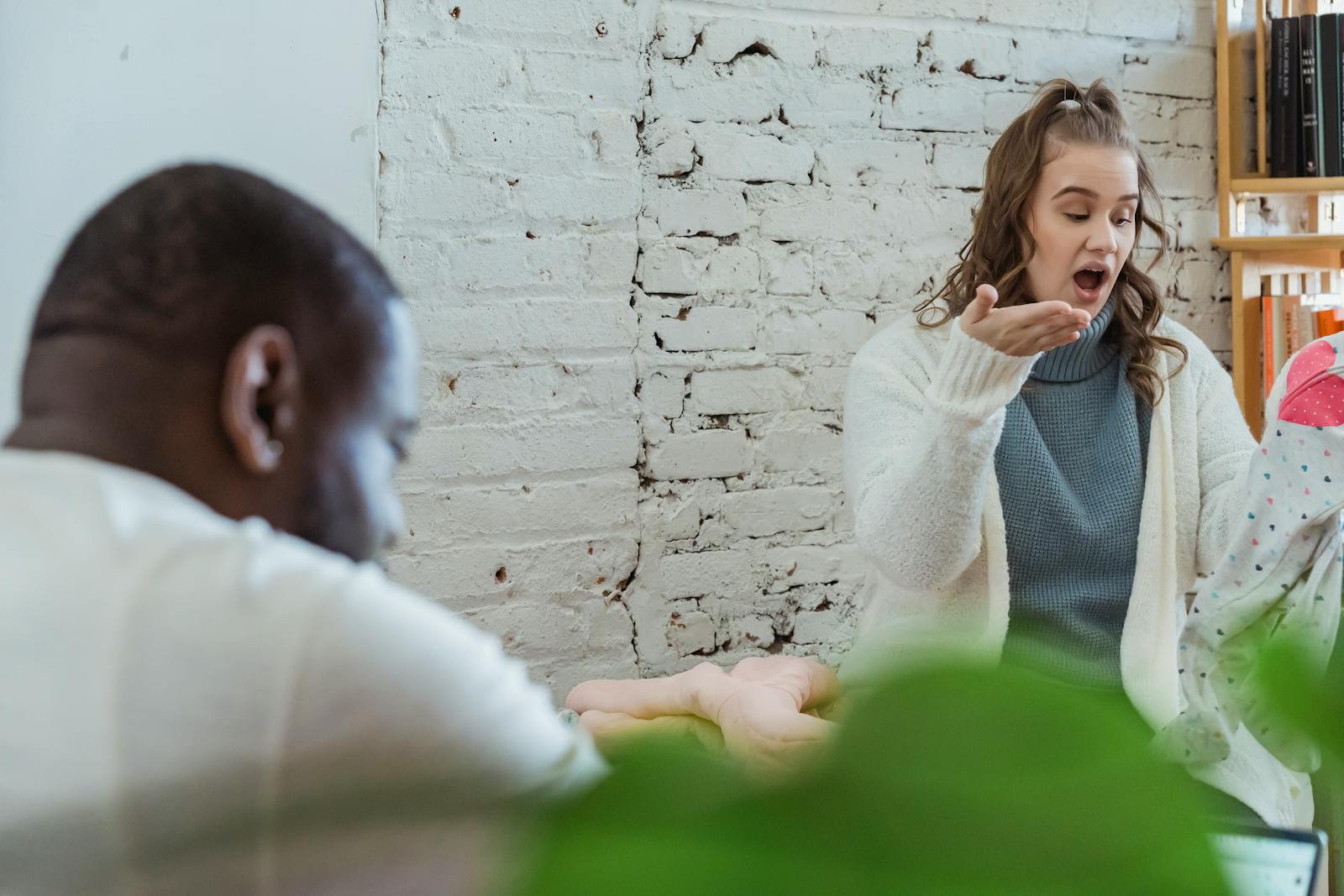 A multiethnic couple engaged in a heated discussion at home, conveying emotional tension.