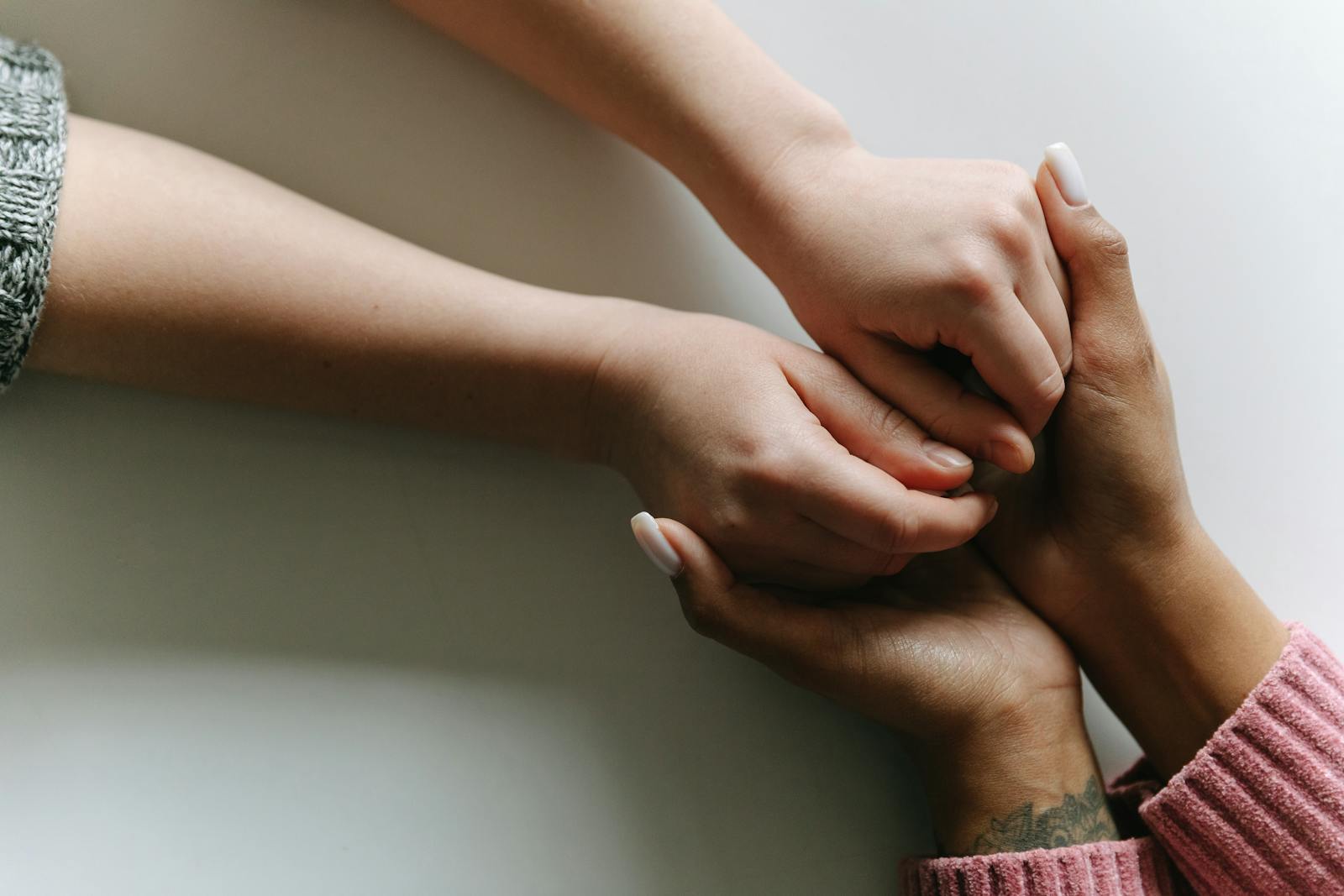 Close-up of diverse hands holding, symbolizing care, support, and friendship.