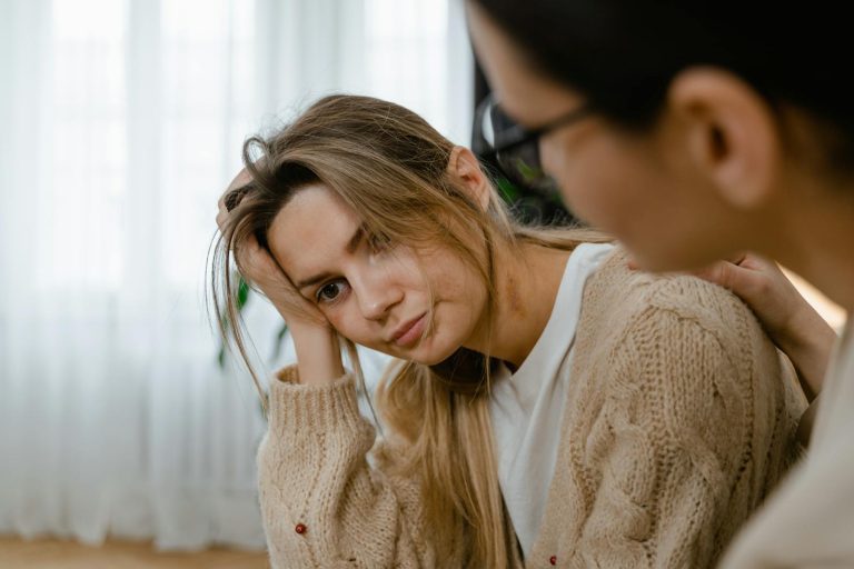 Woman receiving comforting support, showing empathy and understanding in a thoughtful indoors setting.