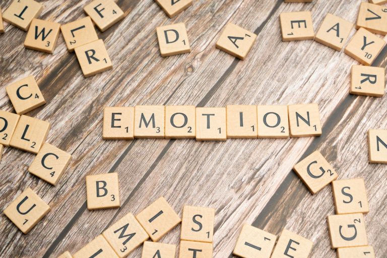 scrabble tiles spelling the word emotion on a wooden surface
