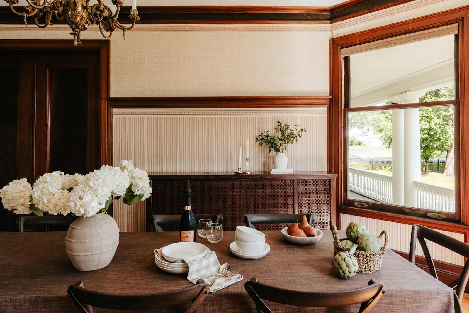 A dining room table with a vase of flowers on it