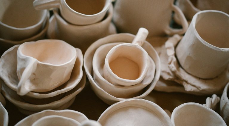 A pile of white cups and saucers sitting on top of a table