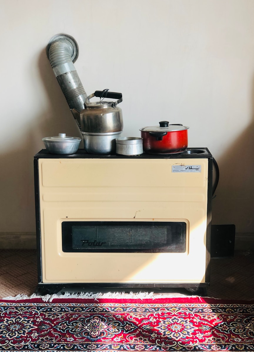 stainless steel cooking pot on white microwave oven