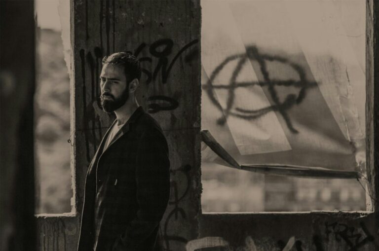 Sepia-toned portrait of a man with graffiti, adding a melancholic and rebellious feel.