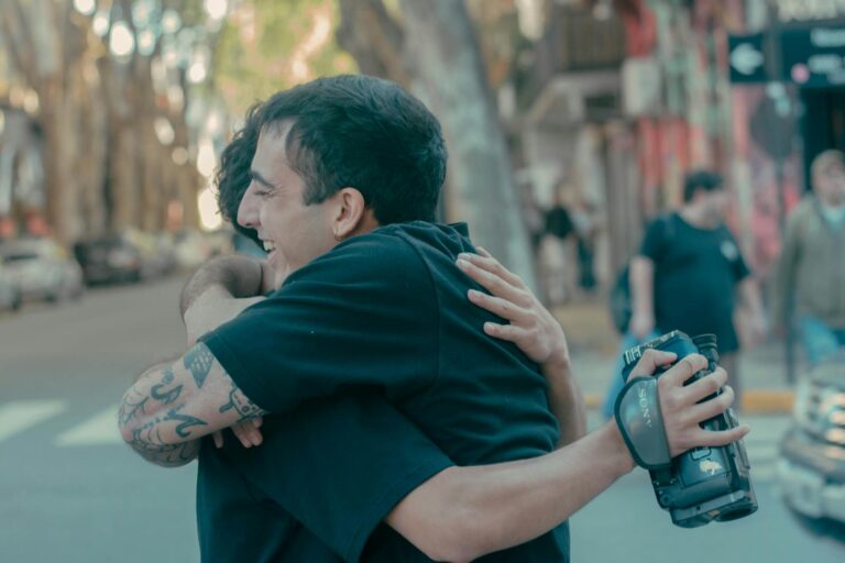 Two friends sharing a heartfelt embrace on a bustling Argentinian street.