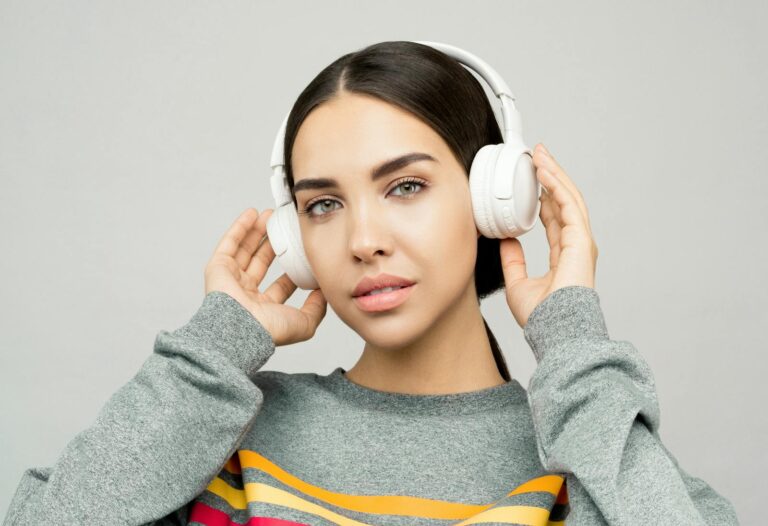 Portrait of a young woman wearing headphones, enjoying music indoors with a casual expression.
