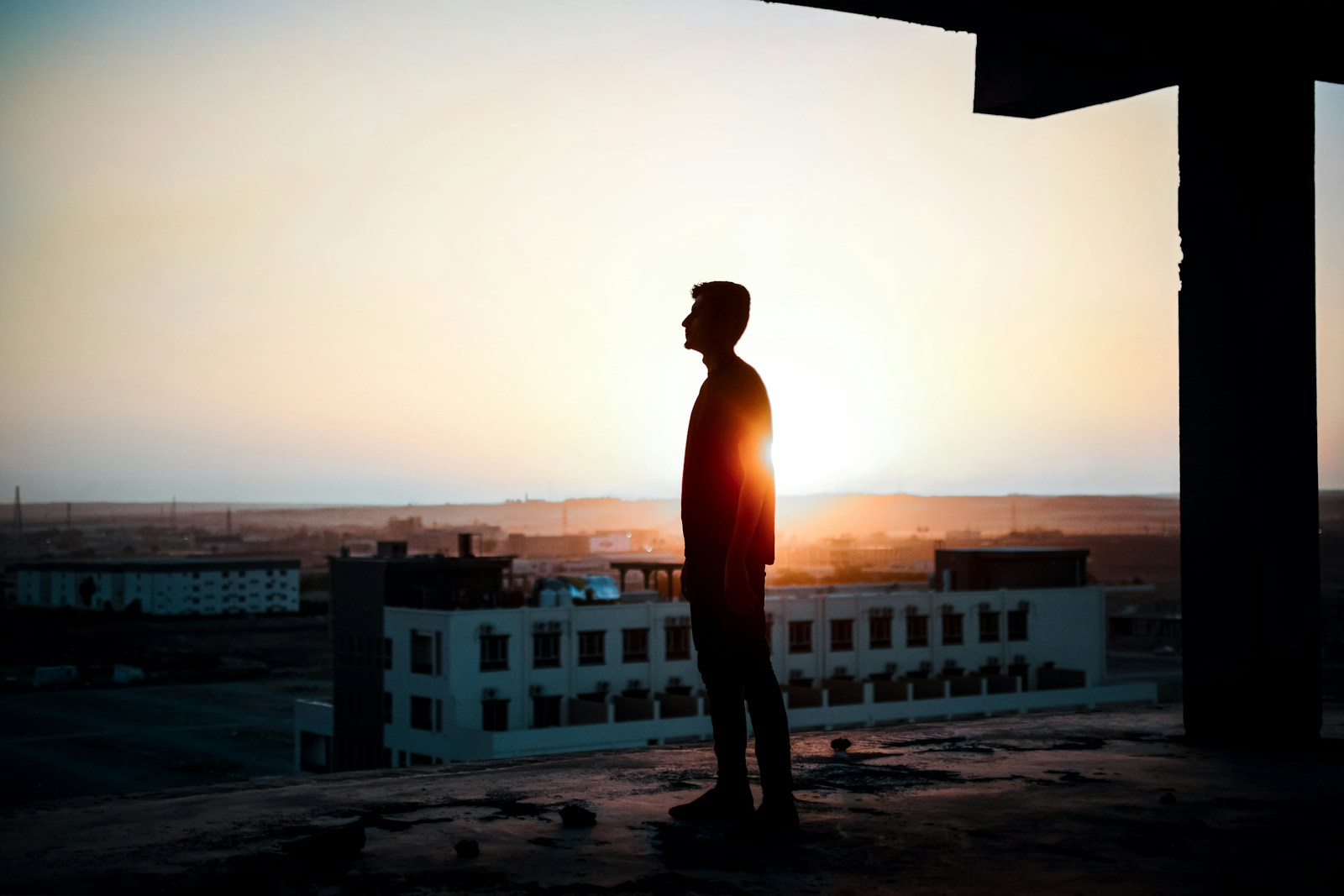 a man standing on top of a roof next to a building